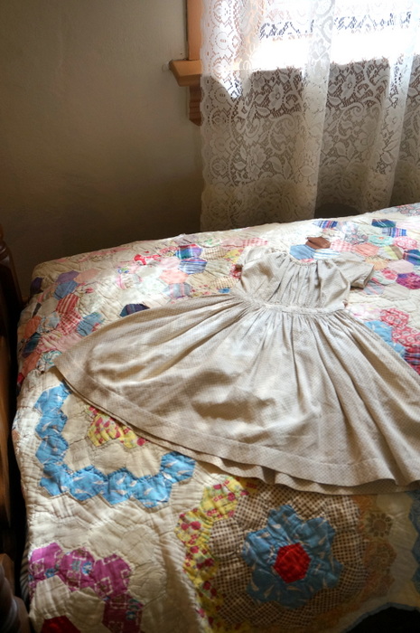 antique child's dress and quilt