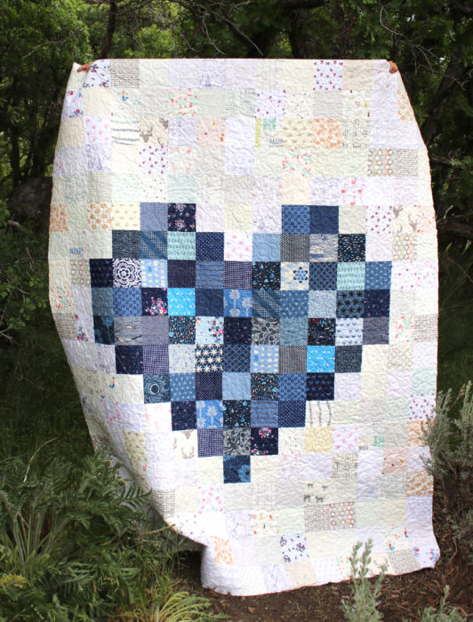 25 Favorite Charm Square Quilts & Projects featured by top US quilting blog, Diary of a Quilter: Navy patchwork pixelated heart quilt