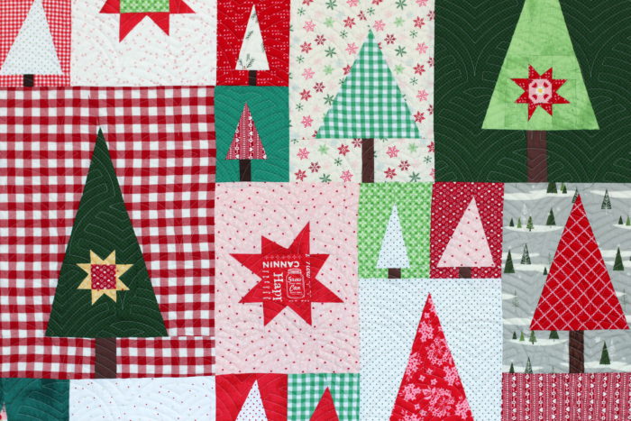New Patchwork Forest Quilt Pattern: Pine Hollow Version by popular quilting blog, Diary of a Quilter: image of a red, white, and green patchwork forest tree quilt.