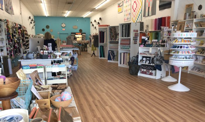 Pintuck & Purl - Modern Fabric and Knitting Shop by popular quilting blog, Diary of a Quilter: image of various spools of thread, knitting yarn, and fabric displays inside Pintuck and Purl.