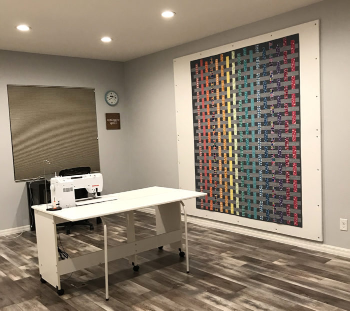 How to Build a Quilt Design Wall by Christa Watson by popular quilting blog, Diary of a Quilter: image of a sewing room with a large quilt design wall with a quilt on it.