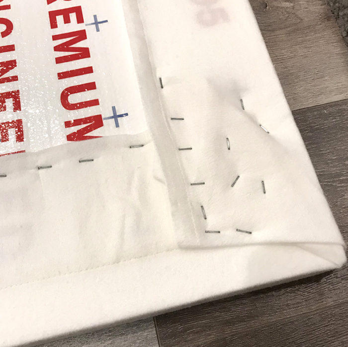 How to Build a Quilt Design Wall by Christa Watson by popular quilting blog, Diary of a Quilter: image of a king size white flannel sheet being stapled to the back side of a foam core insulation board.