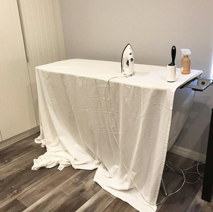How to Build a Quilt Design Wall by Christa Watson by popular quilting blog, Diary of a Quilter: image of a king size white flannel sheet on an ironing board with an iron, lint roller, and spray bottle.