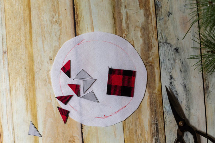DIY Heirloom Christmas Ornament guest post by Coral + Co by popular Utah quilting blog, Diary of a Quilter: image of cut out piece of an Ohio star template on black and red plaid fabric.