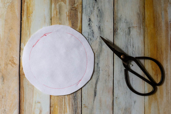 DIY Heirloom Christmas Ornament guest post by Coral + Co by popular Utah quilting blog, Diary of a Quilter: image of a round piece of white felt and some fabric scissors.