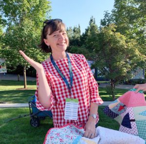 A Year in Review: Looking back at 2019 + Looking forward to 2020 by popular Utah quilting blog: image of a woman sitting outside and holding a quilt on her lap.