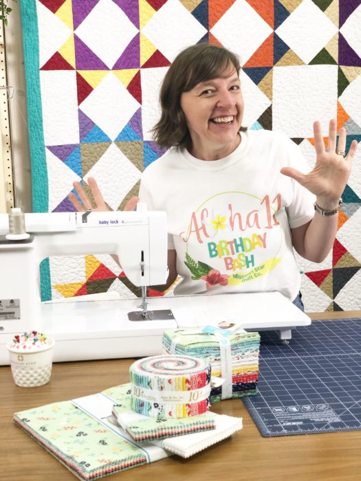 Birthday Bash at Missouri Star Quilt Company by popular quilting blog, Diary of a Quilter: image of woman standing next to a sewing machine inside the Missouri Star Quilt Company. 