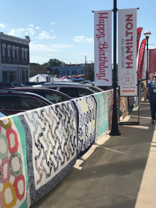 Birthday Bash at Missouri Star Quilt Company by popular quilting blog, Diary of a Quilter: image of quilts hanging outside of the Missouri Star Quilt company. 