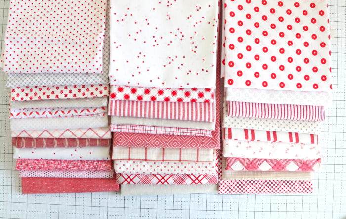 Welcome to the Patchwork Forest Quilt Along! by popular quilting blog, Diary of a Quilter: image of a various red and white fabrics.