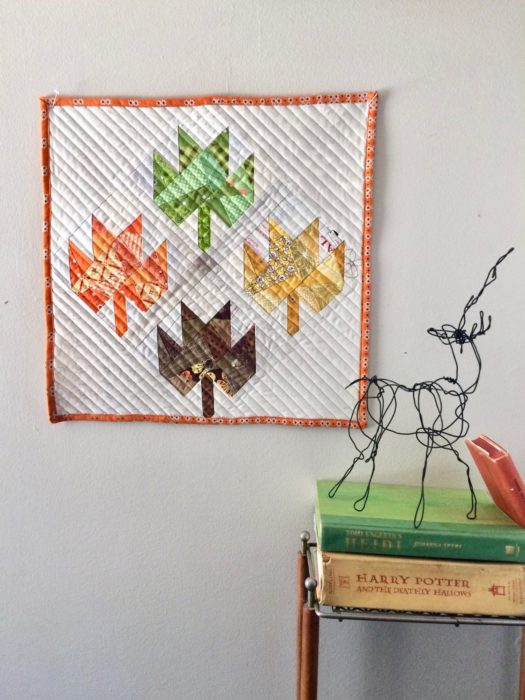 Scrappy Maple Leaf Quilt Pattern Tutorial by guest writer Leila Gardunia by popular quilting blog, Diary of a Quilter: image of a maple leaf quilt hanging on a wall. 