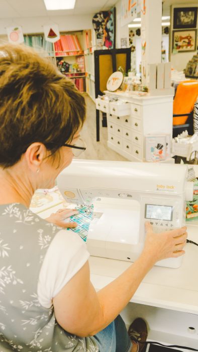 Shop Local - My Girlfriend's Quilt Shoppe + Giveaway by popular Utah quilting blog, Diary of a Quilter: image of a woman sitting at a sewing machine.