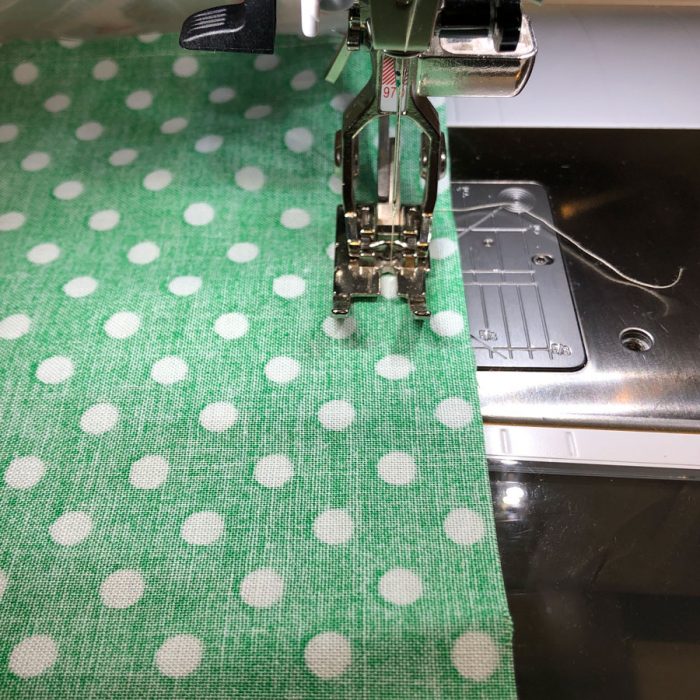 Perfect Size Custom Gift Bags Tutorial by May Chappell by popular Utah sewing blog, Diary of a Quilter: image of a custom gift bag in a sewing machine. 