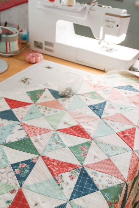 Basting a quilt sandwich with quilt top, batting, and backing layered 