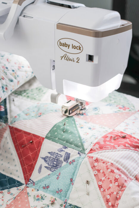 Straight-line quilting stitches being sewn on a quilt with a walking foot on a home sewing machine