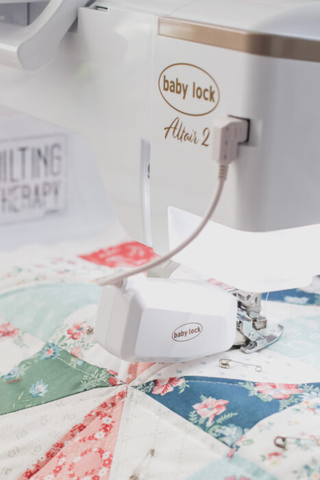 Baby Lock Dual-feed system engaged on a home sewing machine to help feed quilt layers evenly while quilting