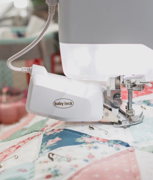 Dual-feed system engaged on a Baby Lock home sewing machine to help feed quilt layers evenly while quilting