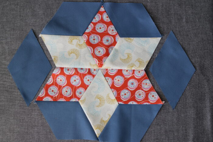 Finished six-pointed star quilt block surrounded by background diamonds