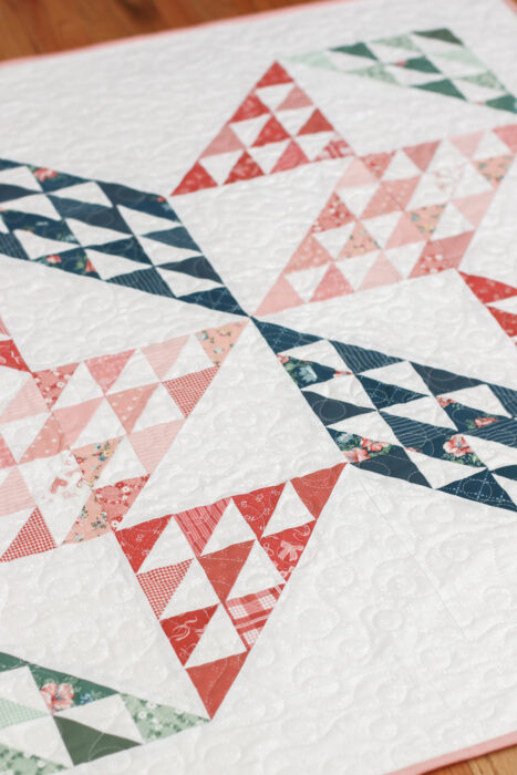Sugarhouse Star baby quilt hanging flat, crisp star points, soft pastel prints from Mary Catherine collection on tonal white print