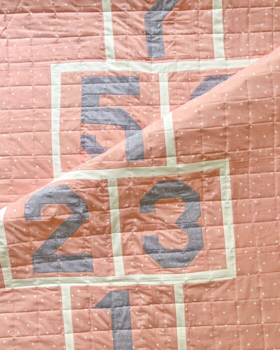 Detail of the “Sidewalk Quilt” showing quilting, piecing, and number blocks.
