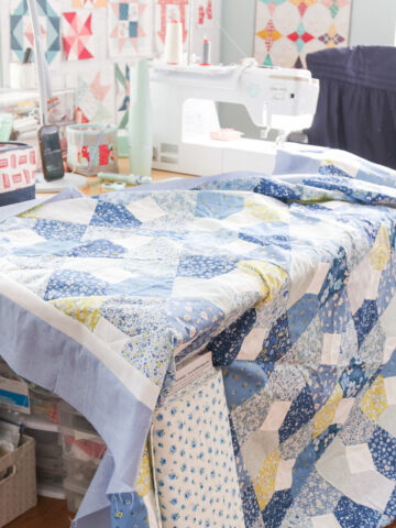 Amy Smart Diary of a Quilter working on a blue Liberty patchwork quilt